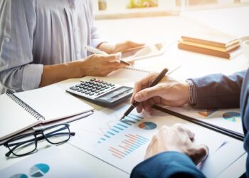 business man financial inspector and secretary making report, calculating or checking balance.