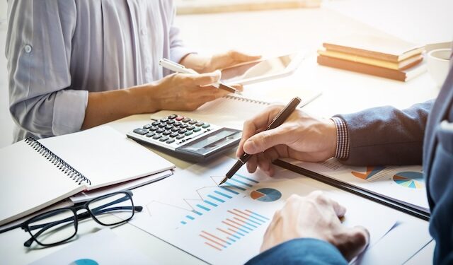 business man financial inspector and secretary making report, calculating or checking balance.