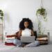 woman sitting on bed holding laptop