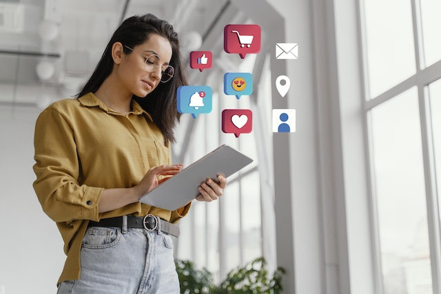 woman holding device surrounded by social media app icons