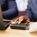 Man and woman reviewing bills and financial documents to track expenses, money management for a debt free lifestyle. Couple doing their household accounting with a calculator. Close up.